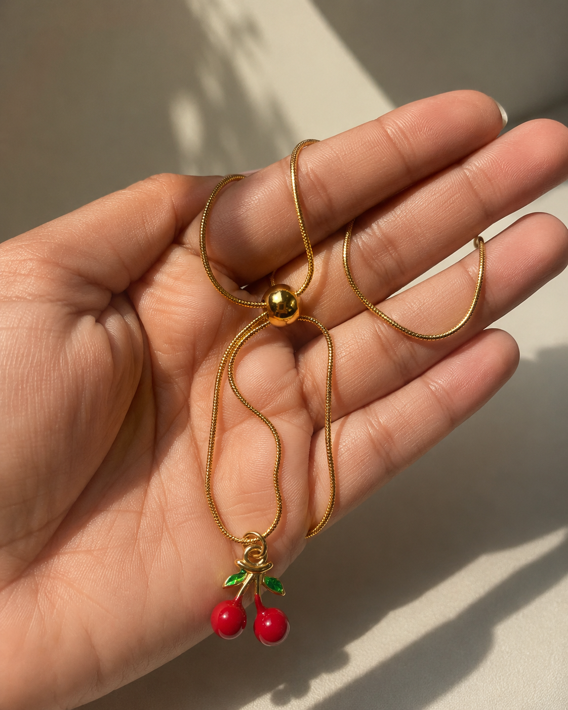 Zinmeerjewells gold chain necklace featuring an adjustable slider design and a unique pinterest style pendant cherry charm, highlighting premium anti tarnish jewelry Pakistan.
